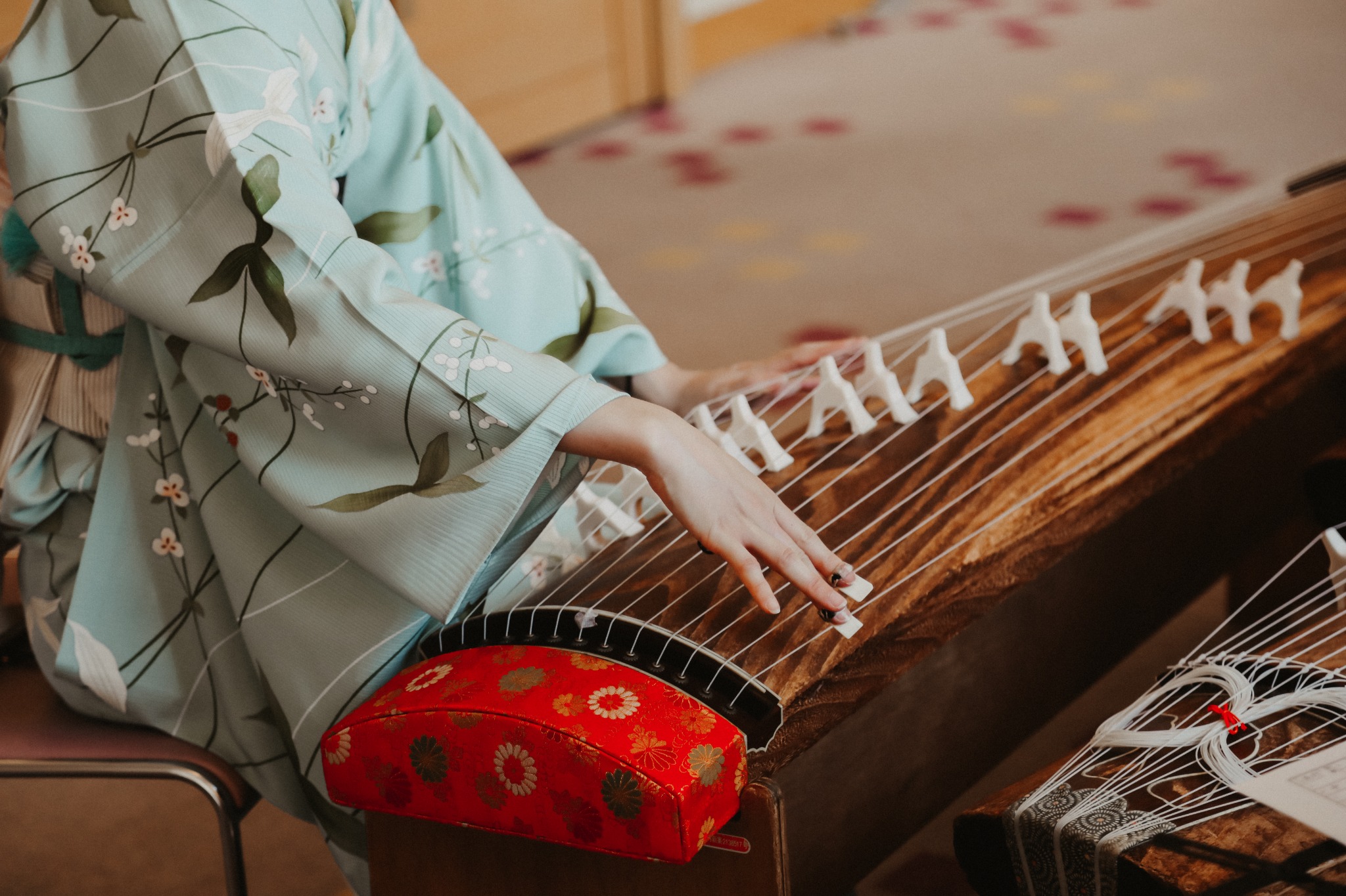A musician in kimono playing the koto, a traditional Japanese string instrument